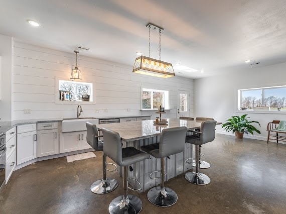 dining area with sink and wooden walls