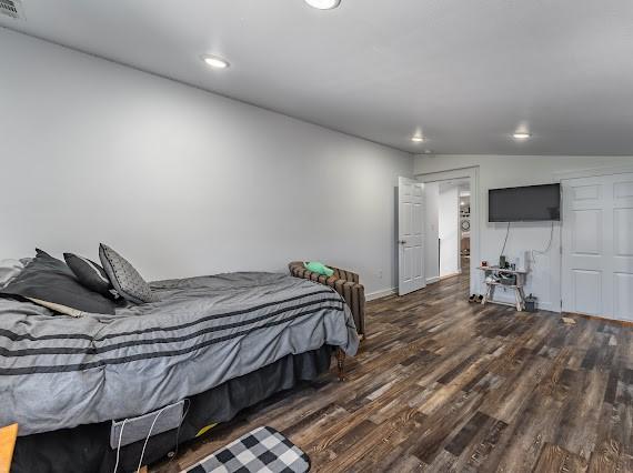 bedroom featuring dark wood-type flooring and vaulted ceiling