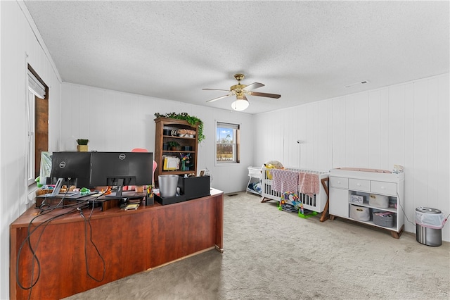 home office with wood walls, carpet flooring, and a textured ceiling