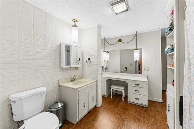 bathroom featuring vanity, toilet, hardwood / wood-style flooring, and a textured ceiling