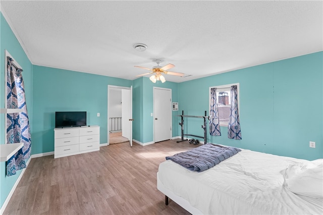 bedroom featuring ceiling fan, a textured ceiling, and light hardwood / wood-style floors