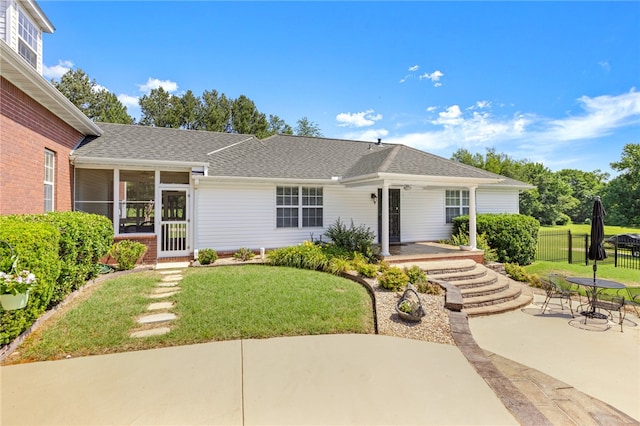 ranch-style house featuring a sunroom, a patio area, and a front yard