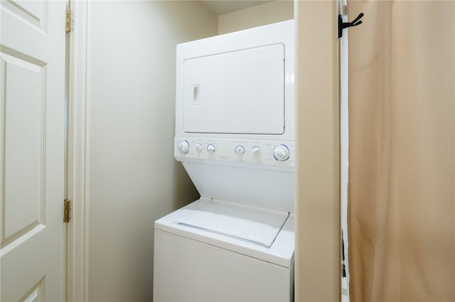 washroom featuring stacked washing maching and dryer