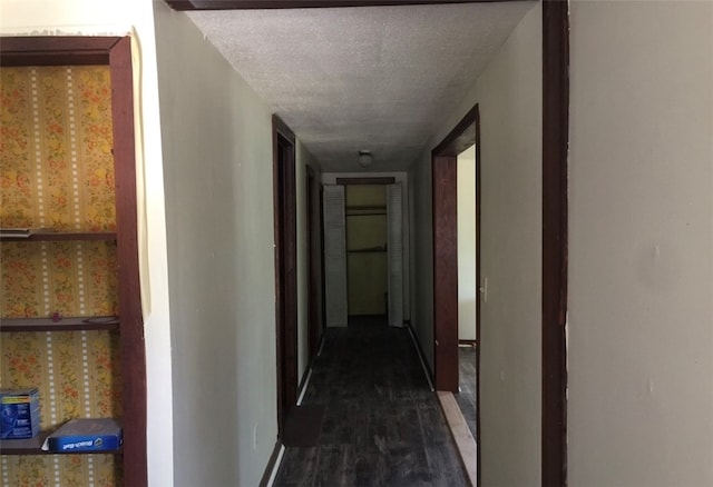 hallway featuring a textured ceiling and dark hardwood / wood-style flooring