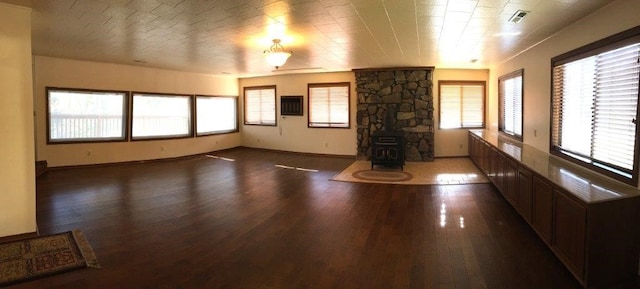 18960 Coppermine Rd, Rogers, AR 72756 - unfurnished living room with a wood stove, visible vents, and wood finished floors