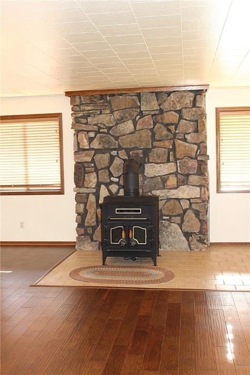 18960 Coppermine Rd, Rogers, AR 72756 - details featuring a wood stove, baseboards, and wood finished floors