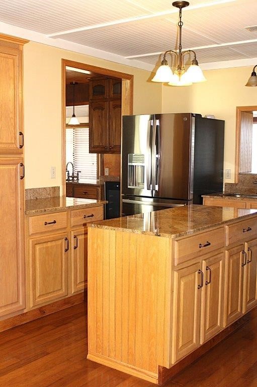 18960 Coppermine Rd, Rogers, AR 72756 - kitchen featuring stone counters, a center island, dark wood-style flooring, a notable chandelier, and stainless steel fridge