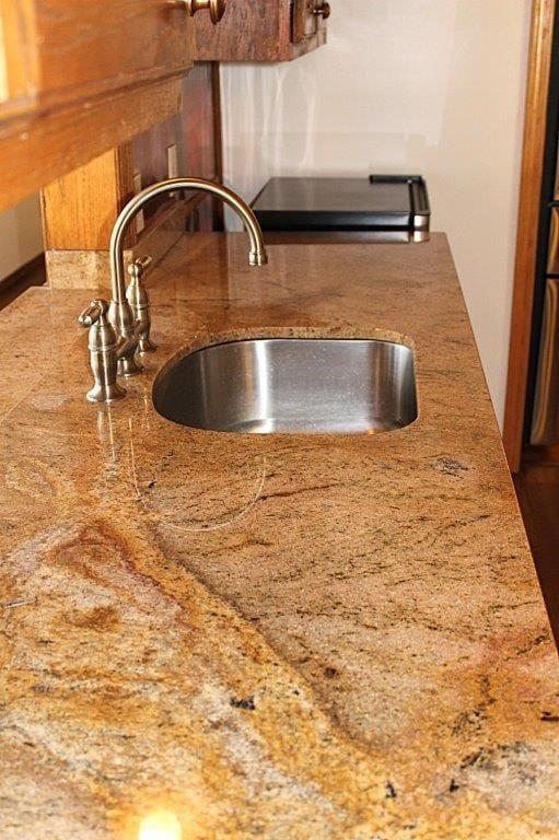 18960 Coppermine Rd, Rogers, AR 72756 - room details with a sink and light stone countertops