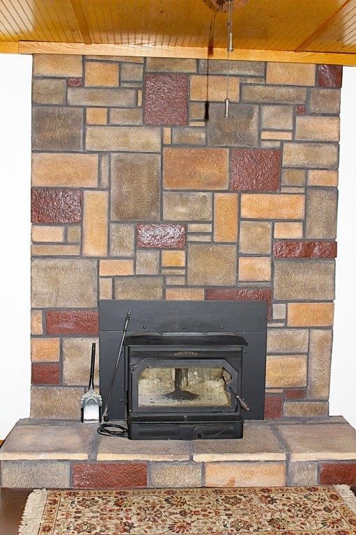 18960 Coppermine Rd, Rogers, AR 72756 - room details with a wood stove and wooden ceiling