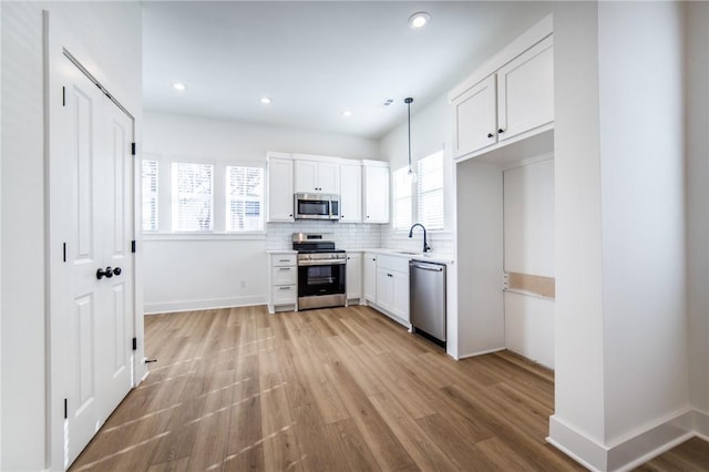 kitchen featuring a healthy amount of sunlight, white cabinetry, and stainless steel appliances