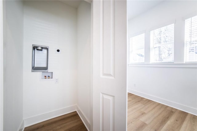 clothes washing area with electric dryer hookup, hookup for a washing machine, and light wood-type flooring