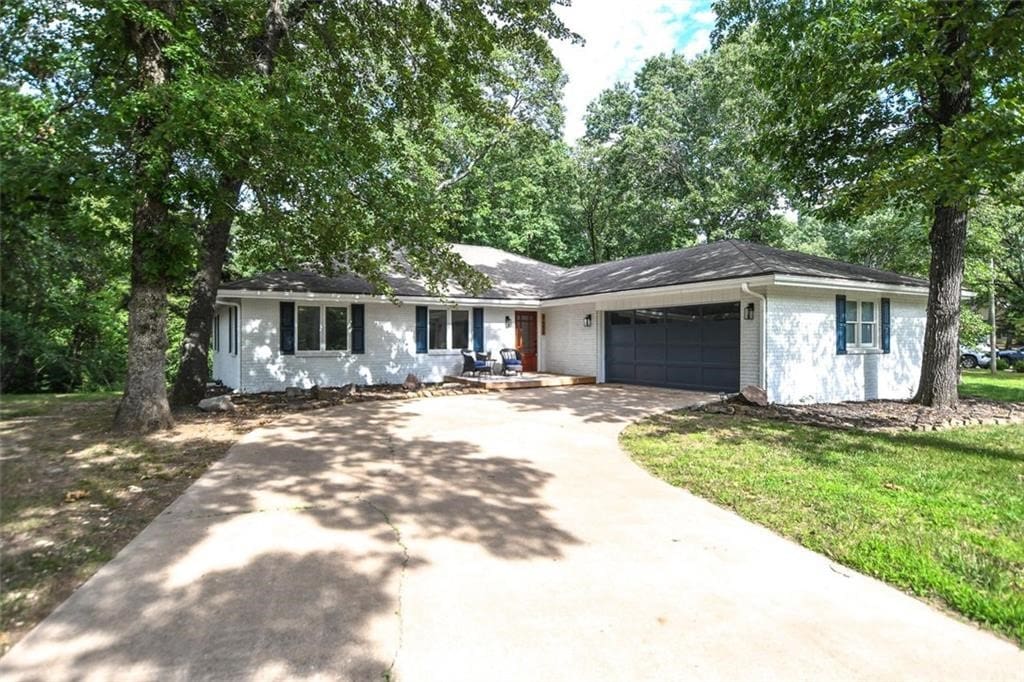 ranch-style house featuring a front yard and a garage