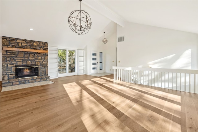 unfurnished living room with a stone fireplace, wood-type flooring, high vaulted ceiling, a notable chandelier, and beamed ceiling