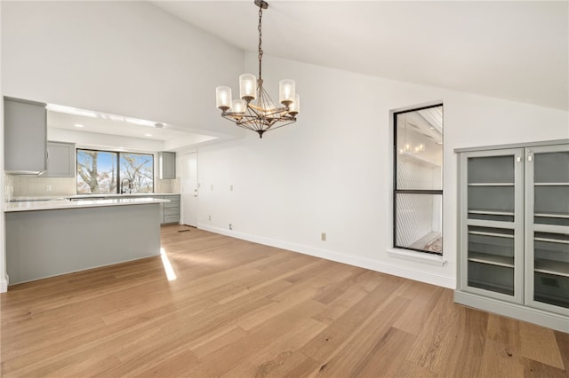 interior space featuring high vaulted ceiling, a chandelier, sink, and light wood-type flooring