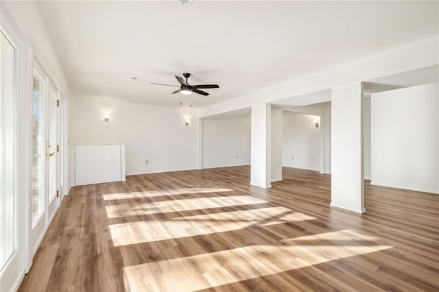 interior space featuring ceiling fan, radiator heating unit, and light wood-type flooring