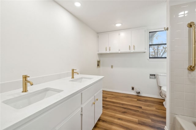 laundry area featuring wood-type flooring, hookup for a washing machine, and sink