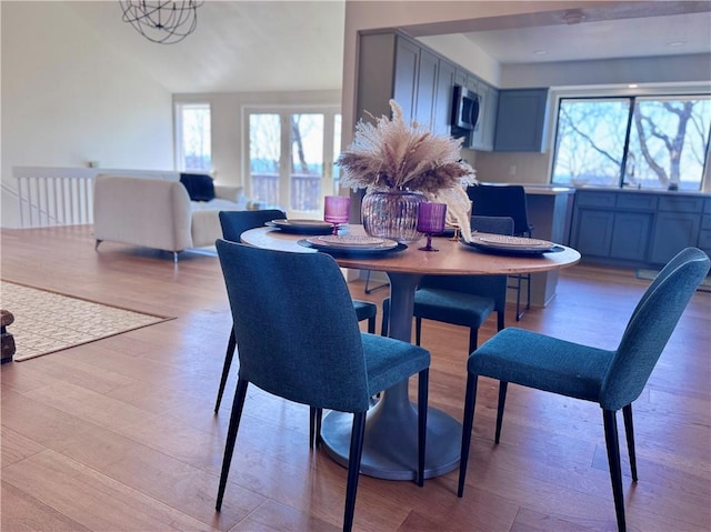 dining room featuring lofted ceiling and light hardwood / wood-style flooring