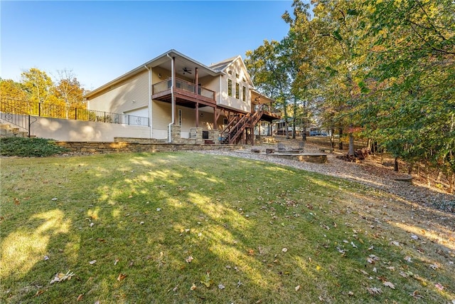 back of house with ceiling fan, a wooden deck, and a lawn