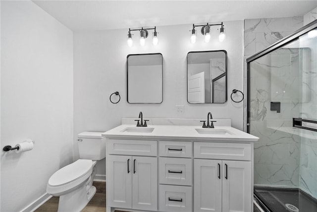 bathroom with hardwood / wood-style floors, vanity, a shower with shower door, and toilet