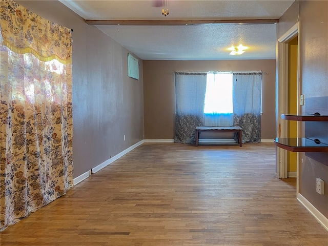 empty room with light hardwood / wood-style flooring and a textured ceiling