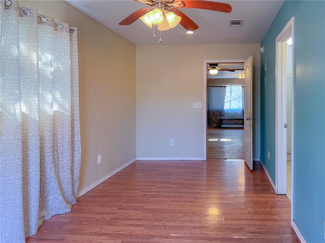 empty room with wood-type flooring and ceiling fan