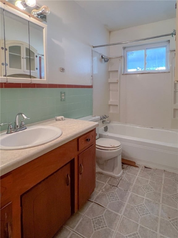 full bathroom with tile walls, toilet, shower / bathtub combination, vanity, and tile patterned flooring