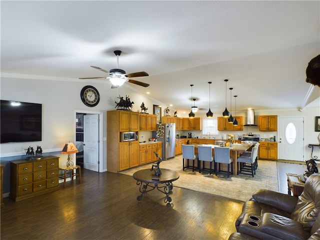 living room featuring ceiling fan, sink, hardwood / wood-style floors, lofted ceiling, and ornamental molding