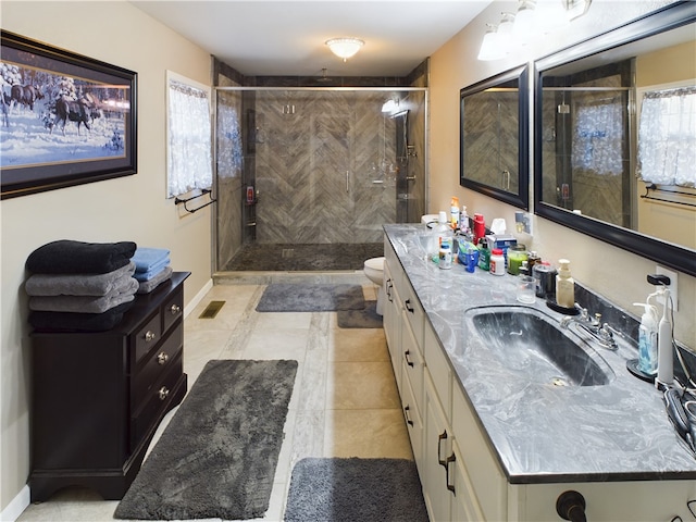 bathroom with tile patterned floors, vanity, a tile shower, and toilet