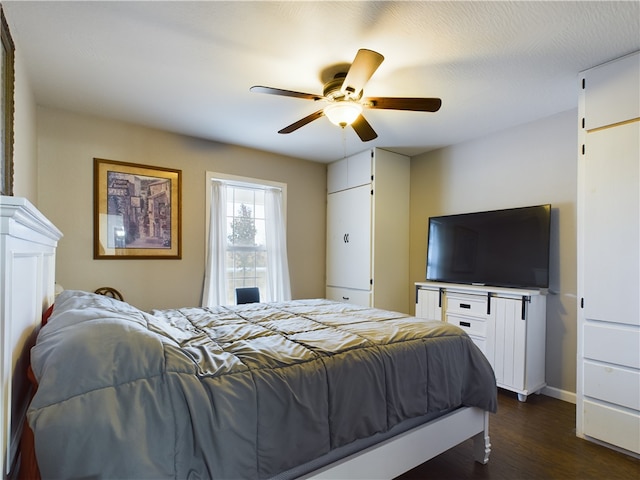 bedroom with ceiling fan, dark hardwood / wood-style flooring, and a textured ceiling