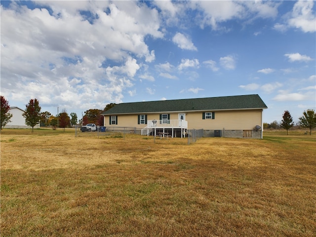 rear view of house with a lawn and a deck