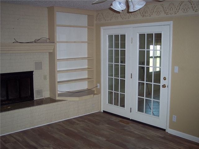 unfurnished living room featuring a textured ceiling, ceiling fan, a fireplace, and dark hardwood / wood-style flooring