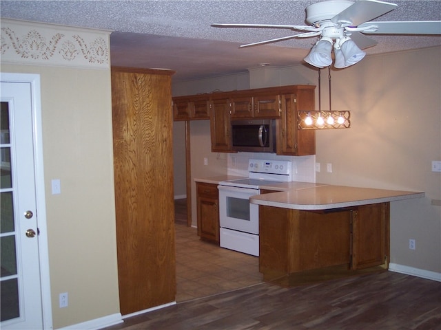 kitchen featuring dark hardwood / wood-style floors, white electric range, hanging light fixtures, kitchen peninsula, and ceiling fan