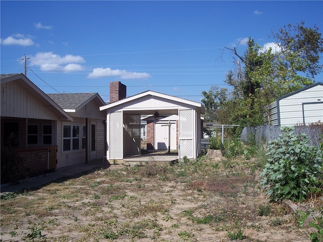 rear view of property featuring ceiling fan