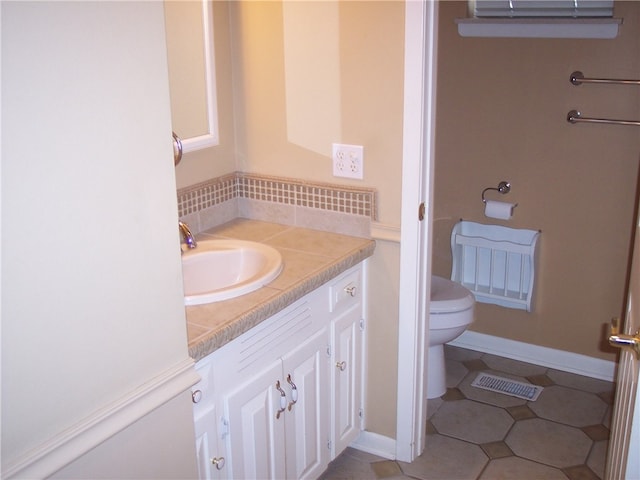 bathroom featuring vanity, toilet, and tile patterned flooring