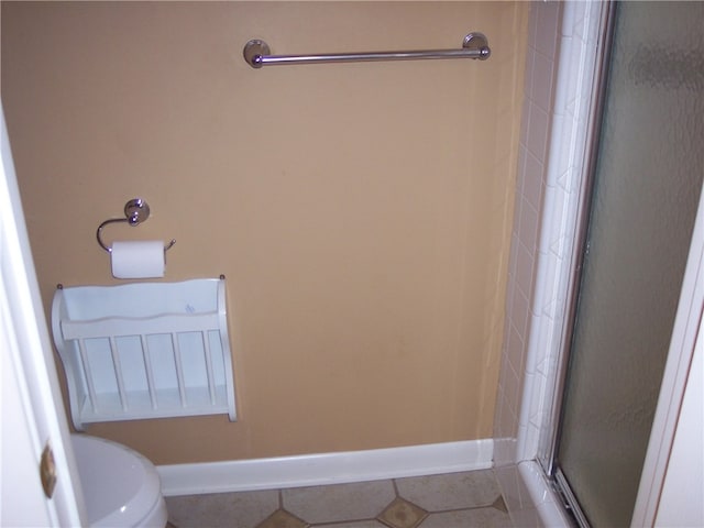 bathroom featuring toilet, tile patterned floors, and walk in shower