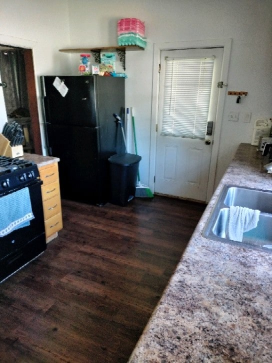 kitchen with black appliances, sink, and dark hardwood / wood-style flooring