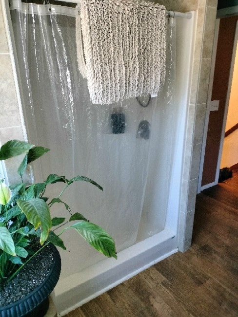 bathroom with a shower with curtain and wood-type flooring