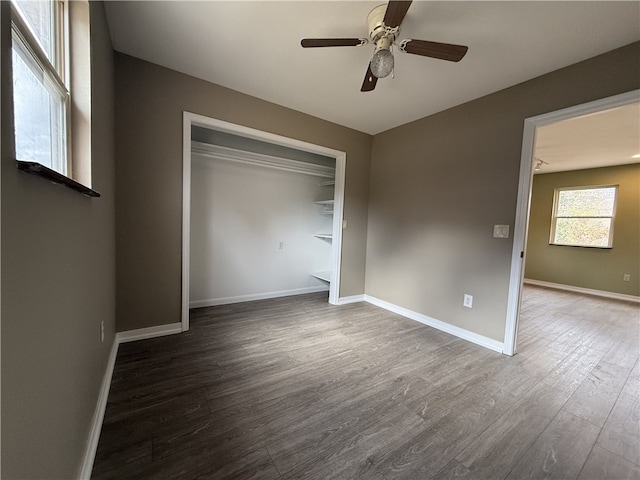 unfurnished bedroom featuring a closet, dark wood-type flooring, and ceiling fan