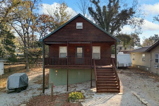 view of front of home with stairs, driveway, and a porch