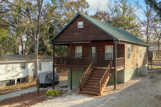 log cabin featuring central AC unit and a porch