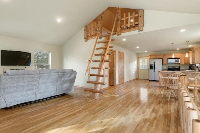 living area featuring light wood-style floors, recessed lighting, plenty of natural light, and stairway