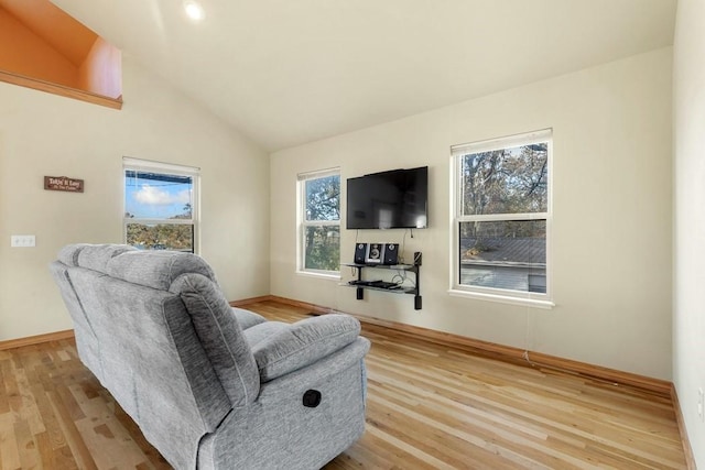 sitting room with light wood finished floors and vaulted ceiling