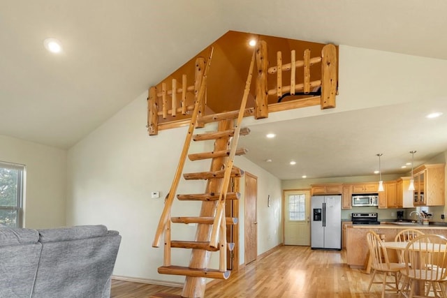 kitchen with stainless steel appliances, a wealth of natural light, glass insert cabinets, and light wood-style flooring