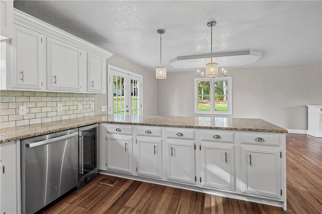 kitchen featuring kitchen peninsula, white cabinetry, dark wood-type flooring, and pendant lighting