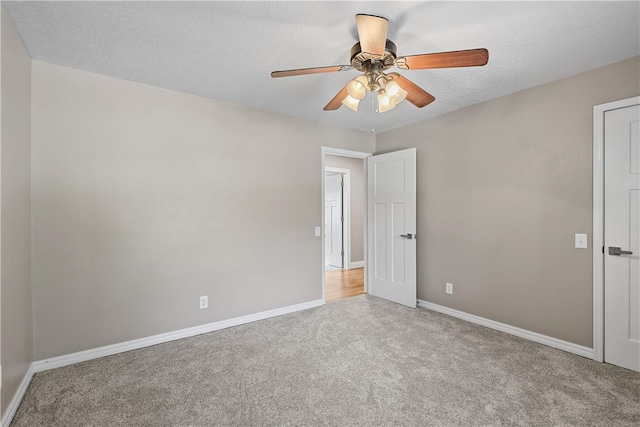 carpeted empty room featuring ceiling fan and a textured ceiling