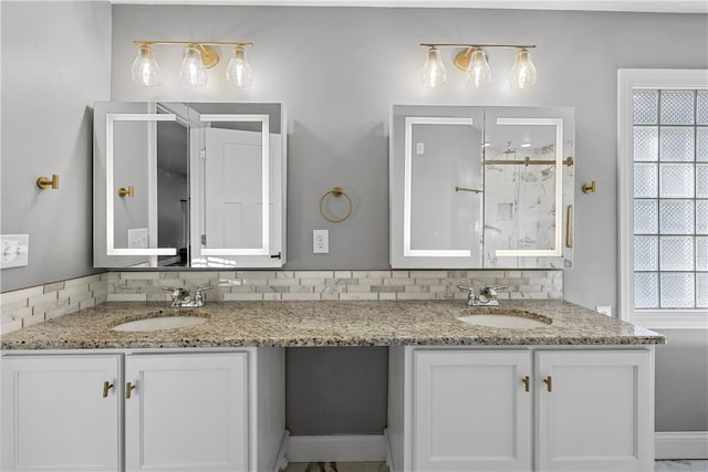 bathroom featuring vanity, decorative backsplash, and a shower with door