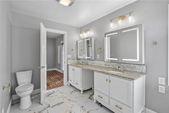 bathroom featuring tasteful backsplash, a textured ceiling, hardwood / wood-style flooring, toilet, and vanity