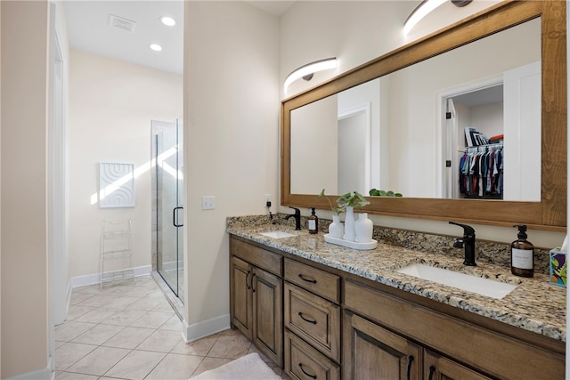 bathroom featuring vanity, a shower with shower door, and tile patterned flooring