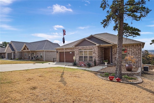 view of front of home featuring central AC, a front yard, and a garage