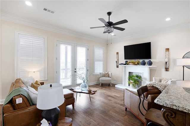 living room with crown molding, ceiling fan, french doors, and dark hardwood / wood-style flooring